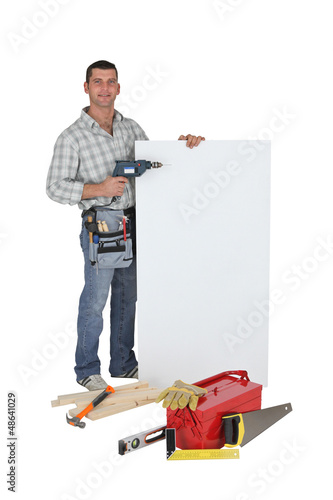 Photo: Carpenter using drill to point to poster Carpenter using drill to point to poster