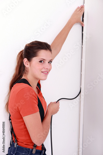 Photo: Woman placing electrical cable Woman placing electrical cable
