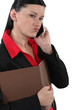 Doubtful businesswoman talking on her mobile phone