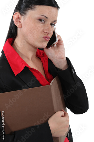 Photo: Doubtful businesswoman talking on her mobile phone Doubtful businesswoman talking on her mobile phone