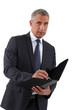 Businessman writing in a folder