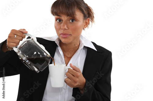 Photo: woman in a suit drinking a cup of coffee woman in a suit drinking a cup of coffee