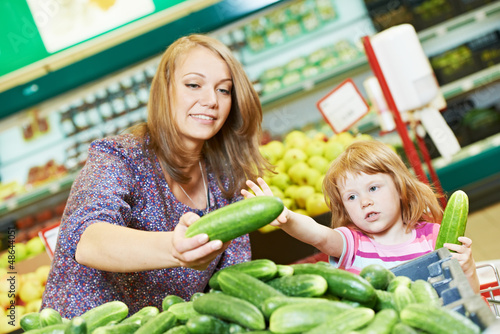 Photo: woman and little girl shopping fruits woman and little girl shopping fruits