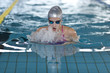 young girl swims breaststroke in the swimming pool