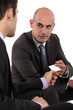 Two businessmen exchanging cards
