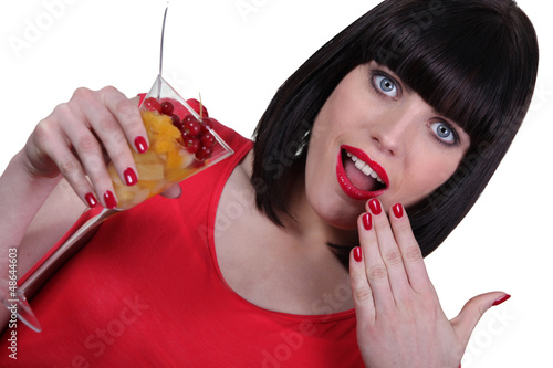 Photo: young woman eating a fruit salad young woman eating a fruit salad