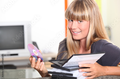 Photo: Young woman choosing a dvd Young woman choosing a dvd