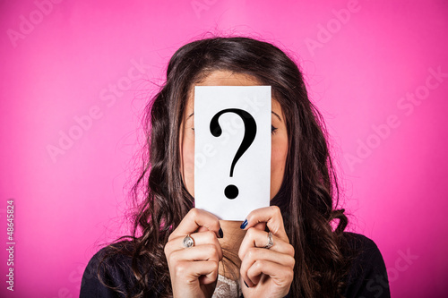 Photo: Doubtful Woman holding Question Mark Doubtful Woman holding Question Mark