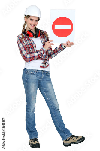 Photo: Woman holding a road sign. Woman holding a road sign.