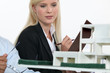 Architect and co-worker looking at model building