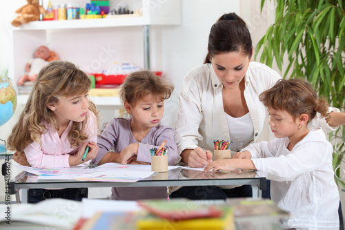 Photo: Woman helping a group of girls with their homework Woman helping a group of girls with their homework