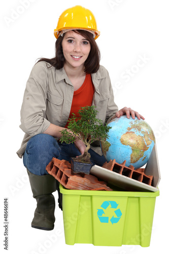 Photo: Female builder with recyclable waste Female builder with recyclable waste