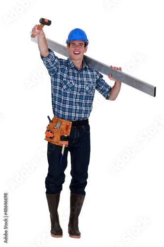 Photo: Cheerful builder holding rubber mallet in the air Cheerful builder holding rubber mallet in the air