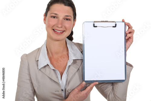Photo: Businesswoman pointing to blank clip-board Businesswoman pointing to blank clip-board