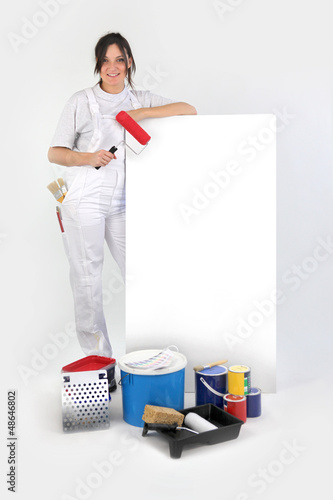 Photo: Decorator stood by blank advertisement board holding roller Decorator stood by blank advertisement board holding roller