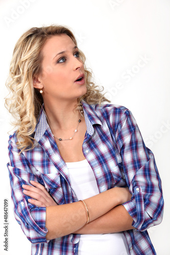 Photo: surprised young woman standing with crossed hands surprised young woman standing with crossed hands
