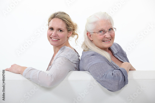 Photo: Mother and daughter sitting on white sofa Mother and daughter sitting on white sofa