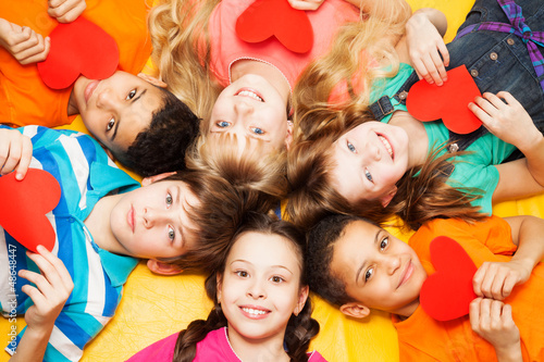 Photo: Kids laying in circle with hearts in their hands Kids laying in circle with hearts in their hands