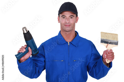 Photo: Tradesman holding a paintbrush and a screw gun Tradesman holding a paintbrush and a screw gun