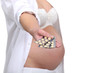 A pregnant woman handing pills.