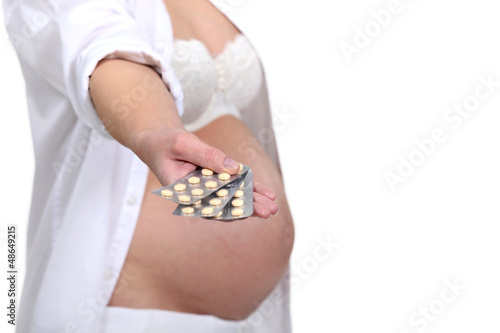 Photo: A pregnant woman handing pills. A pregnant woman handing pills.