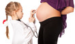 a cute girl is listening to her mother's belly