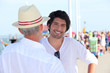 Grandfather and grandson with people in the background