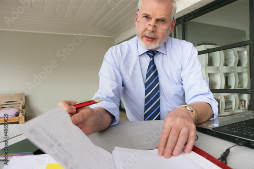 Photo: senior businessman working at his desk senior businessman working at his desk