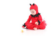 Baby with a red demon disguise watching a pacifier