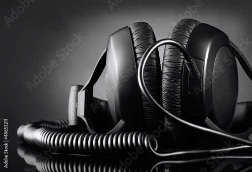 Photo: Modern headphones over dark background Modern headphones over dark background