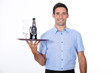 A waiter bringing a bottle of liquor.