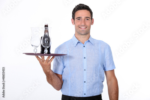 Photo: A waiter bringing a bottle of liquor. A waiter bringing a bottle of liquor.