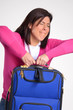 Joven mujer viajera sujetando una valija,maleta.