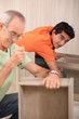 Grandfather with grandson assembling furniture