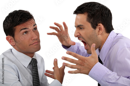 Photo: Man yelling at his apathetic colleague Man yelling at his apathetic colleague