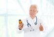 Photo: Thumb up Asian doctor holding bottle pills Thumb up Asian doctor holding bottle pills