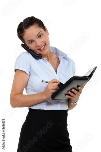 Photo: Businesswoman scheduling an appointment into her agenda Businesswoman scheduling an appointment into her agenda