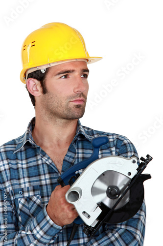 Photo: Man holding circular saw Man holding circular saw