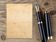 Fountain pen and vintage paper on old wooden background