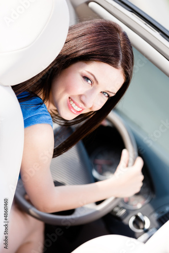 Photo: Portrait of young female driver turning back Portrait of young female driver turning back