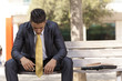 Photo: Frustrated businessman sit at the bench park Frustrated businessman sit at the bench park