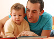 Foto: Padre e hijo compartiendo y leyendo un cuento. Padre e hijo compartiendo y leyendo un cuento.