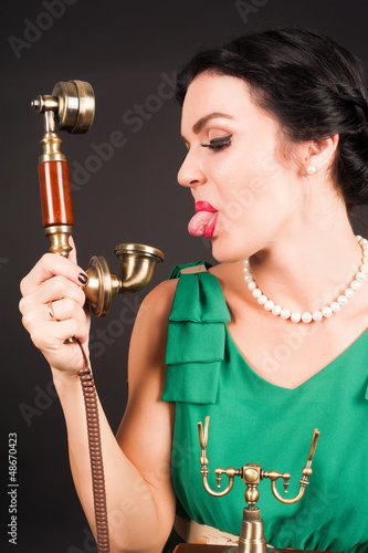 Photo: Attractive woman showing tongue into phone Attractive woman showing tongue into phone