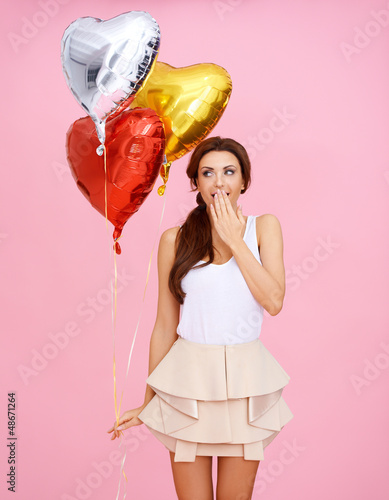 Photo: Cute woman with heart shaped party balloons Cute woman with heart shaped party balloons