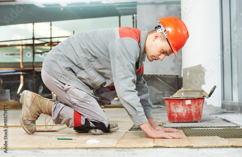 Photo: tiler at industrial floor tiling renovation work tiler at industrial floor tiling renovation work