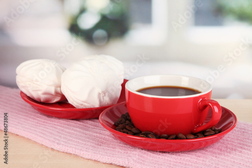 Photo: cup of coffee with scarf on table in room cup of coffee with scarf on table in room