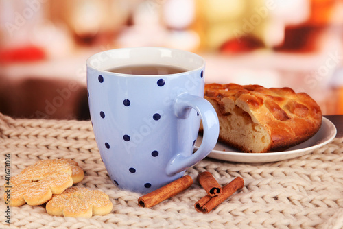 Photo: cup of tea with scarf on table in room cup of tea with scarf on table in room