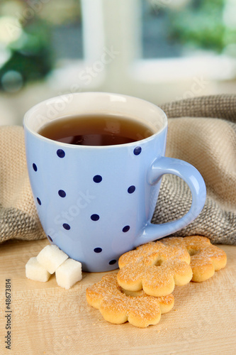 Photo: cup of tea with scarf on table in room cup of tea with scarf on table in room