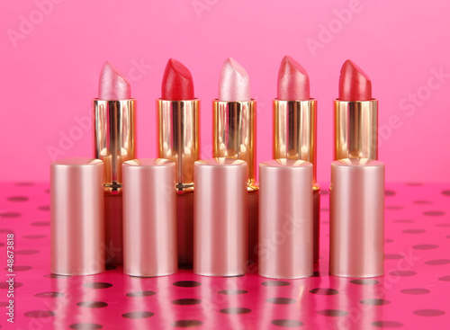 Photo: Lipsticks on table on pink background Lipsticks on table on pink background