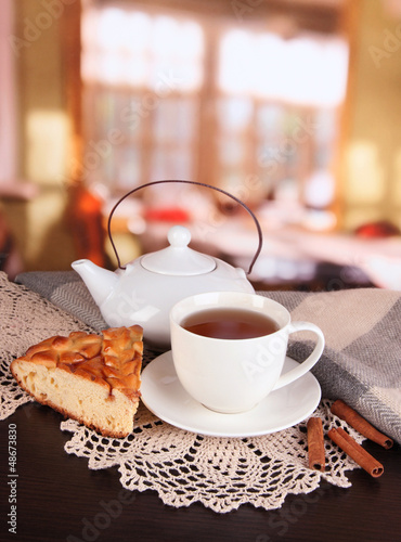 Photo: cup of tea with scarf on table in room cup of tea with scarf on table in room